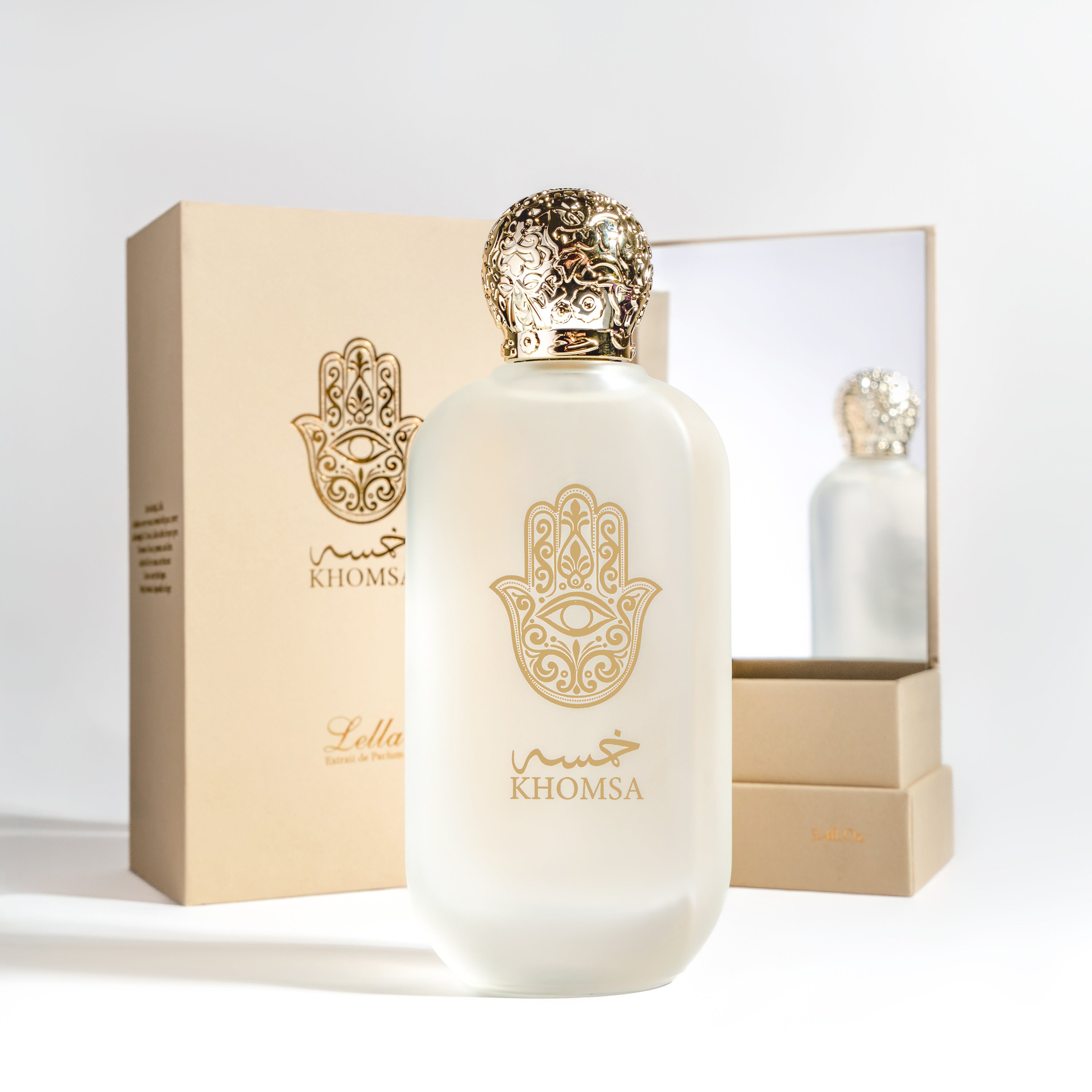 White perfume bottle with gold accents and 'Khomsa' branding on a light gray background